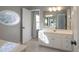 Bathroom with a double sink vanity, neutral tile flooring, a large mirror, and an oval window at 228 Black Mountain Dr, Fort Mill, SC 29708
