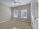 Bright bedroom featuring two large windows, neutral paint, carpeted floor and recessed ceiling fan at 228 Black Mountain Dr, Fort Mill, SC 29708