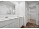 Modern bathroom with double sink vanity, large mirror, and tile flooring with a doorway to a walk-in closet at 295 Bezelle Ave, York, SC 29745