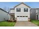 Charming two-story home featuring a white garage door, neutral siding and manicured landscaping at 302 Bezelle Ave, York, SC 29745