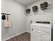 Well-lit laundry room featuring a modern white washer and dryer, storage shelves, and convenient hanging hooks at 302 Bezelle Ave, York, SC 29745