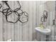Stylish powder room featuring a pedestal sink, decorative wall art and striped wallpaper at 302 Bezelle Ave, York, SC 29745