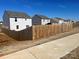 View of neighborhood houses behind a wooden privacy fence at 329 Aniston Ln, Shelby, NC 28152
