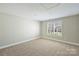 Bright bedroom with plush carpet, neutral paint, and a large window for natural light at 4219 Kronos Pl, Charlotte, NC 28210