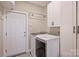 Well-equipped laundry room featuring modern washer and dryer with white shaker cabinets at 4219 Kronos Pl, Charlotte, NC 28210