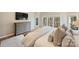 Bright main bedroom with large windows, TV and dresser. Hardwood floors and light carpet at 4219 Kronos Pl, Charlotte, NC 28210
