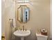 Cozy powder room with classic fixtures, including a pedestal sink and decorative mirror at 4219 Kronos Pl, Charlotte, NC 28210