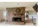 Inviting living room featuring a cozy brick fireplace and a staircase at 4220 Honeysuckle Rd, Rock Hill, SC 29732