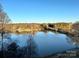 Scenic lake view surrounded by trees, with clear blue sky and a boat dock on the water at 4370 Reed Creek Dr, Sherrills Ford, NC 28673