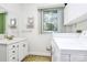 Bright bathroom features a vanity with mirror and lighting, and a window adjacent to the laundry machines at 4607 Carmel Vista Ln, Charlotte, NC 28226