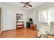 Bedroom with hardwood floors, ceiling fan, and natural light from the window with blinds at 4607 Carmel Vista Ln, Charlotte, NC 28226
