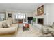 Cozy living room featuring a white brick fireplace, plush seating, and access to sunroom at 4607 Carmel Vista Ln, Charlotte, NC 28226