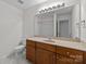 Bathroom with single sink vanity, large mirror, toilet and tile flooring at 471 Doughton Ln, Charlotte, NC 28217
