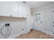 Bright laundry room featuring white cabinetry, modern fixtures, and convenient access to the exterior at 48 Washington Se Ln, Concord, NC 28025