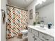 Bathroom with a colorful checkered shower curtain, white vanity, and neutral tile floors at 5212 Spanish Ivy Ln, Indian Land, SC 29707