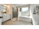 Bright bathroom featuring a soaking tub, glass-enclosed shower, and double vanity at 5212 Spanish Ivy Ln, Indian Land, SC 29707