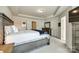 Bright main bedroom with a tray ceiling, dresser, and closet doors at 5212 Spanish Ivy Ln, Indian Land, SC 29707