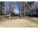 Large backyard featuring mature trees, grass, and a blue sky at 6017 Brace Rd, Charlotte, NC 28211