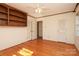 Bedroom featuring hardwood floors, two closets, built-in shelving, and ceiling fan at 6017 Brace Rd, Charlotte, NC 28211