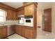 Traditional kitchen featuring wood cabinets, stainless steel dishwasher and vintage appliances with bright wallpaper at 6017 Brace Rd, Charlotte, NC 28211