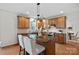 Modern kitchen featuring wood cabinets, granite countertops, and stainless steel appliances, complemented by a cozy breakfast bar at 6040 Graburn'S Ford Dr, Charlotte, NC 28269