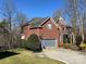 Side view of a beautiful brick home showing manicured lawn, attached garage, mature trees, and the property line at 6040 Graburn'S Ford Dr, Charlotte, NC 28269