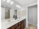 Bright bathroom featuring double sinks, granite countertops, and decorative accents. The shower is visible in the mirror at 6449 Silver Star Ln, Charlotte, NC 28210