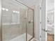 Tiled shower stall with glass enclosure and chrome fixtures in a well-lit bathroom. Shower also has tiled insets at 6449 Silver Star Ln, Charlotte, NC 28210