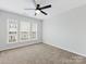 A bright bedroom with a ceiling fan and large window providing ample natural light at 6449 Silver Star Ln, Charlotte, NC 28210