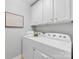 A convenient laundry room with modern washer and dryer, white cabinetry, and neutral wall color at 6449 Silver Star Ln, Charlotte, NC 28210