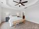 Main bedroom features neutral carpet, ceiling fan, and views of the outdoors at 6449 Silver Star Ln, Charlotte, NC 28210