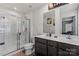 Bathroom with double sink vanity, a large mirror, and a glass door shower, offering style and convenience at 668 Pointe Andrews Sw Dr # 93, Concord, NC 28025