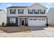 Charming two-story home featuring a two-car garage, gray siding and dark shutters at 668 Pointe Andrews Sw Dr # 93, Concord, NC 28025