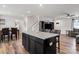 Open-concept layout showcasing kitchen island connecting dining and living areas with wood floors at 668 Pointe Andrews Sw Dr # 93, Concord, NC 28025