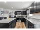 Stylish kitchen featuring granite countertops, stainless steel appliances, dark cabinetry and hardwood floors at 668 Pointe Andrews Sw Dr # 93, Concord, NC 28025