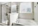 Bright bathroom with a glass-enclosed shower, soaking tub, and modern fixtures at 7035 Walnut Branch Ln, Charlotte, NC 28277