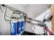 Water filtration system with three blue filters and various pipes and connections on a white wall at 7035 Walnut Branch Ln, Charlotte, NC 28277