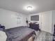 Comfortable bedroom with modern lighting, gray wood floors, and a large TV at 709 High St, Albemarle, NC 28001