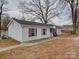 Exterior view of light-sided house with matching trim and a black shingled roof at 709 High St, Albemarle, NC 28001
