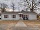 Charming single-story home with light siding, red shutters and covered front porch at 709 High St, Albemarle, NC 28001