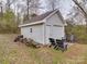 Garage exterior with chairs on a concrete pad leading to the closed garage door at 709 High St, Albemarle, NC 28001