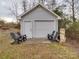 Garage exterior with chairs on a concrete pad leading to the closed garage door at 709 High St, Albemarle, NC 28001