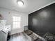 Bright laundry room with modern washer, and gray plank flooring with window at 709 High St, Albemarle, NC 28001