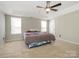 Spacious bedroom features tray ceilings, ceiling fan, and cozy carpeting at 7220 Hidden Creek Dr, Charlotte, NC 28214