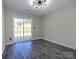 Bedroom featuring gray wood floors and sliding glass doors to outside patio at 7220 Hidden Creek Dr, Charlotte, NC 28214