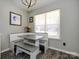 Charming dining area with a built-in booth, table, bench, and a view to the outside through large window at 7220 Hidden Creek Dr, Charlotte, NC 28214