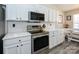Updated kitchen with stainless steel appliances, white cabinetry and countertops, and a dining nook at 7220 Hidden Creek Dr, Charlotte, NC 28214