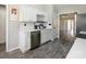 Updated kitchen with stainless steel appliances, white cabinetry and countertops with grey backsplash at 7220 Hidden Creek Dr, Charlotte, NC 28214