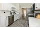 Updated kitchen with stainless steel appliances, white cabinetry and countertops with grey backsplash at 7220 Hidden Creek Dr, Charlotte, NC 28214