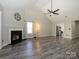 Bright and spacious living room with a fireplace, modern lighting, and expansive wood floors, offering cozy ambiance at 7220 Hidden Creek Dr, Charlotte, NC 28214